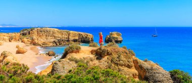 Kırmızı elbiseli kadın Atlantik Okyanusu manzarasının keyfini çıkarıyor- Portekiz 'de Algarve