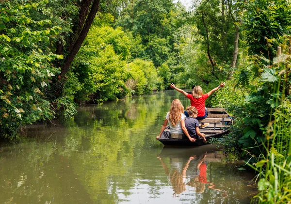 Marais Poitevin 'de tatilde olan Marsh-Happy ailesi. Tekne, kanal ve yeşil bitki örtüsü.