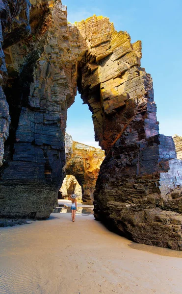 İspanya 'daki katedral plajı doğal kemer, Atlantik okyanusunda etkileyici kaya oluşumu ve kadın turist.