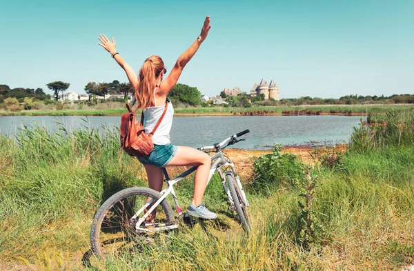 フランス ブルターニュ州モルビハンのすすきの城の景色を楽しむ自転車の女性観光客 — ストック写真