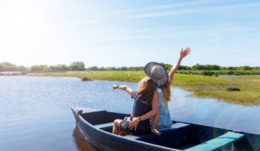 Nehirdeki ahşap sandalda bir aile (Briere bataklığı, Marais de Briere, Fransa, Pays de la Loire)