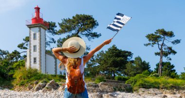 Atlantik kıyısındaki Brittany Deniz Feneri 'nde turizm ve Fransa' da Breton bayrağı tutan kadın turizm (phare de Sainte Marine))