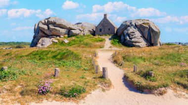 Fransa 'daki Brittany. Meneham köyü Kerlouan, Finistere' deki granit kayaların arasındaki ev.