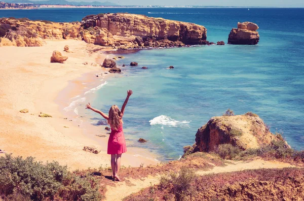 ポルトガルの美しいアルガルヴェビーチのパノラマビューを楽しむ赤いドレスの女性 観光のコンセプト — ストック写真