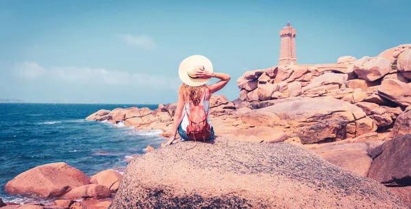 女性の観光客は灯台を見て ピンクの花崗岩の岩と大西洋岸 フランスのPloumanach 平均Ruz灯台 — ストック写真