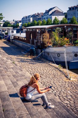 Nantes şehir merkezinde merdivenlerde oturan cep telefonu kullanan bir kadın Fransa, Loire-Atlantique