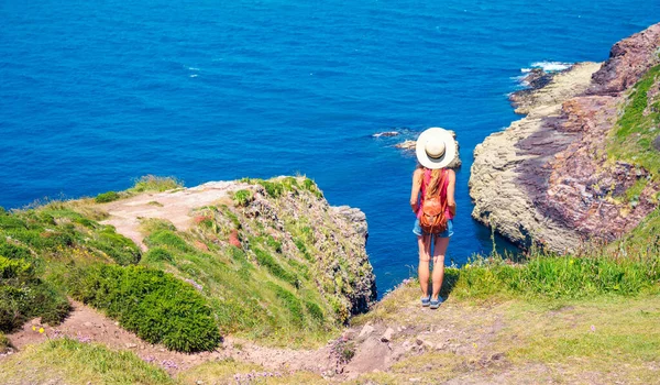Rear View Woman Cliff Wearing Hat Backpack Looking Atlantic Ocean — Stock Photo, Image
