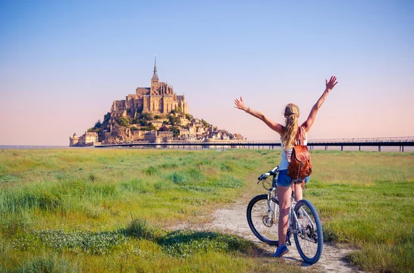 自転車で幸せな女性観光客が日の出でル ミシェルの景色を楽しむ フランスのノルマンディー — ストック写真