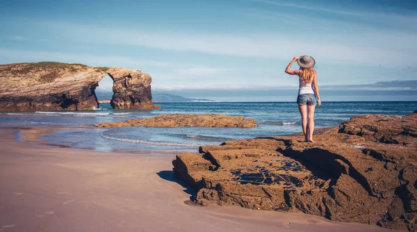 站在岩石上欣赏大西洋和自然拱门美景的女游客 西班牙加利西亚 — 图库照片