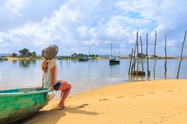 Sahilde balıkçı teknesinde oturan kadın. Arcachon, Fransa 'da Yeni Aquitaine.