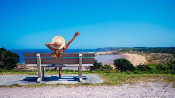 幸せな女性はベンチに座って海を見て 旅行先 リラックスしたコンセプト — ストック写真