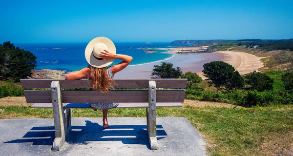 フランスの大西洋 ブルターニュのパノラマビューを楽しむベンチに座っている女性観光客 — ストック写真