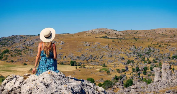 戴帽子 身穿蓝色衣服的女人坐在山顶上观赏风景 幸福的概念 法国尼姆混乱 — 图库照片