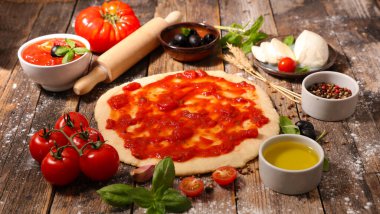 Çiğ hamur hazırlama veya malzemeli pizza: domates sosu, zeytin yağı, mozzarella ve fesleğen