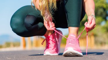 France, July 2023- HOKA running shoe, woman tying laces clipart