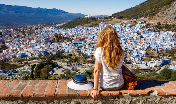 Beyaz kadın, panoramik olarak Şef 'in şehir manzarasına bakıyor. Mavi şehir, Fas.