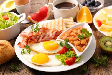 İngiliz kahvaltısı, kızarmış yumurta, tost ve pastırma, fasulye ve kahve fincanı.