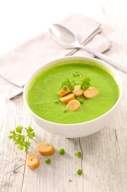 Bir kase yeşil çorba ve kızarmış ekmek.