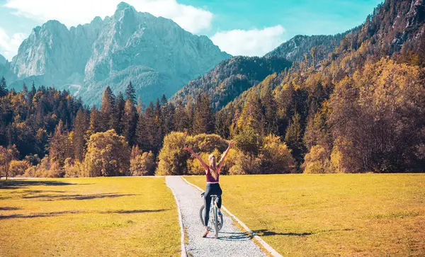 Woman on bike with open arms- Slovenia, travel,sport,active woman concept