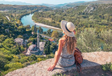 Turizm, seyahat, Bosna-Hersek 'te tatil. Pocitelj' in panoramik manzarasından hoşlanan bir kadın.