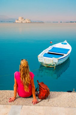 Yunanistan 'ın Nafplio kenti, Argolis bay- Bourtzi kalesinin manzarasının keyfini çıkaran kadın turist 