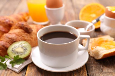 Kahve fincanı, kruvasan ve portakal suyu.