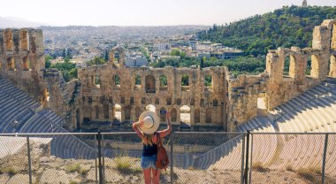 Kadın turist, Herodion Atticus Tiyatrosu, Atina ve Yunanistan 'da akıllı telefonla fotoğraf çekiyor