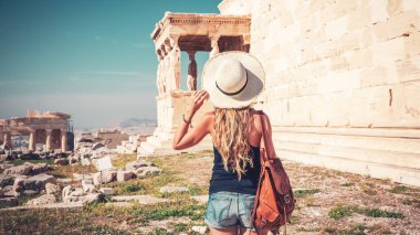 Atina, Akropolis 'in ünlü turistik mekanını ziyaret eden şapka ve çanta taşıyan tatilci Yunanistan' da seyahat, tatil veya turizm turizmi