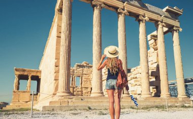 Akropolis, Atina 'daki tapınağa bakan kadın turist ve Yunan bayrağı Yunanistan' da seyahat, tatil veya turizm