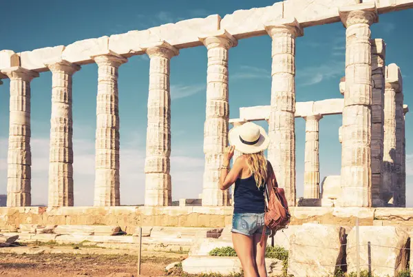Yunanistan 'da antik harabeleri ziyaret eden şapka ve çanta taşıyan kadın turist (Poseidon Tapınağı))
