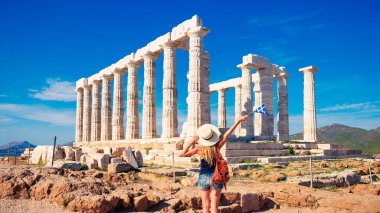Yunanistan 'da Atina yakınlarındaki Poseidon, Cape Sounion antik tapınağının keyfini süren genç bayan turist