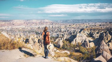 Kapadokya 'da kaya oluşumundan keyif alan genç bir kadının arka planı: Seyahat, turizm, Türkiye' de seyahat beldesi.