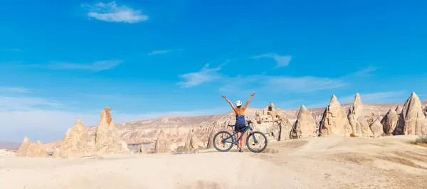 Happy woman in bike in Cappadocia, Turkey- travel, adventure, vacation concept