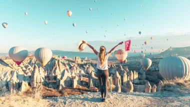 Genç bayan turist kapadokya üzerinde uçan renkli sıcak hava balonu gibi görünüyor. Türkiye 'de seyahat, tatil, turizm.