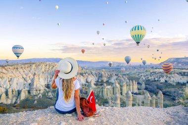 Kapadokya üzerinde uçan renkli sıcak hava balonlu genç bayan turist... Türkiye 'de seyahat, tatil, turizm