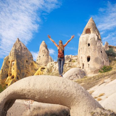Kapadokya 'daki mutlu kadın turist, baca ve mağara hindisi.
