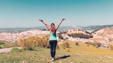 Antequera şehrinin panoramik manzarasının keyfini çıkaran Analusia, İspanya, Malaga gibi kaleli genç bayan turistin arka görüntüsü