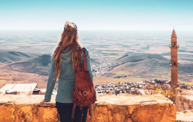 Türkiye 'nin doğusunda panoramik manzaralı Mardin köyüne bakan kadın gezgin