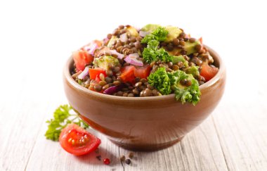 Bir kase mercimek salatası domates ve soğanlı.