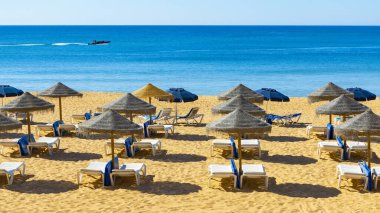 Şezlonglu ve şemsiyeli tropik plaj. Tatil, yaz tatili, turistik tatil.