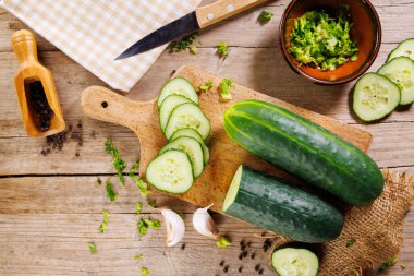 Ağaç kesme tahtasındaki dilimlenmiş salatalığın üst görüntüsü, organik ve taze.