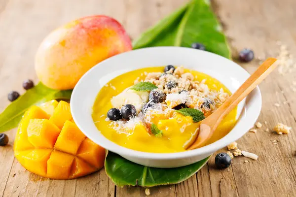 Granola, Blueberry ve Mango 'lu Smoothie Bowl. Tahta Arkaplanda Sağlıklı Kahvaltı