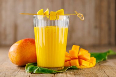 Bir bardak mango suyu veya smoothie. Diyet, sağlıklı beslenme ve vitamin açısından zengin içecek konseptleri için idealdir.