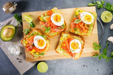 Avokado, füme somon ve yumurta ile ekmekli tost. Sağlıklı kahvaltı ve gurme yemek fikirleri için ideal.