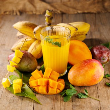 Taze meyve suyu ya da mango, muz ve tutku meyveli smoothie. Sağlıklı beslenme ve tropikal içecekler için mükemmel.
