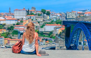 Porto 'daki ünlü köprü ve şehir manzarasına bakan kadın turist. Portekiz
