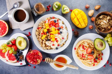 Müsli, taze meyve, krep ve kahve fincanlı sağlıklı kahvaltı masası.