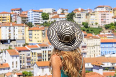 Portekiz 'deki şehir manzarasına bakan şapkalı genç bir kadının dikiz aynası.