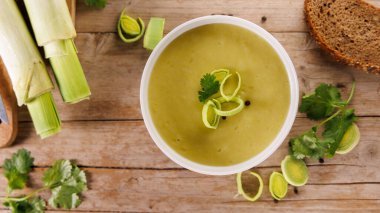 Ahşap zemin üzerinde bir kase pırasa çorbası