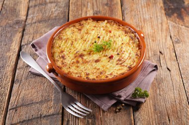 Patates graten, ahşap arka planda çoban turtası.